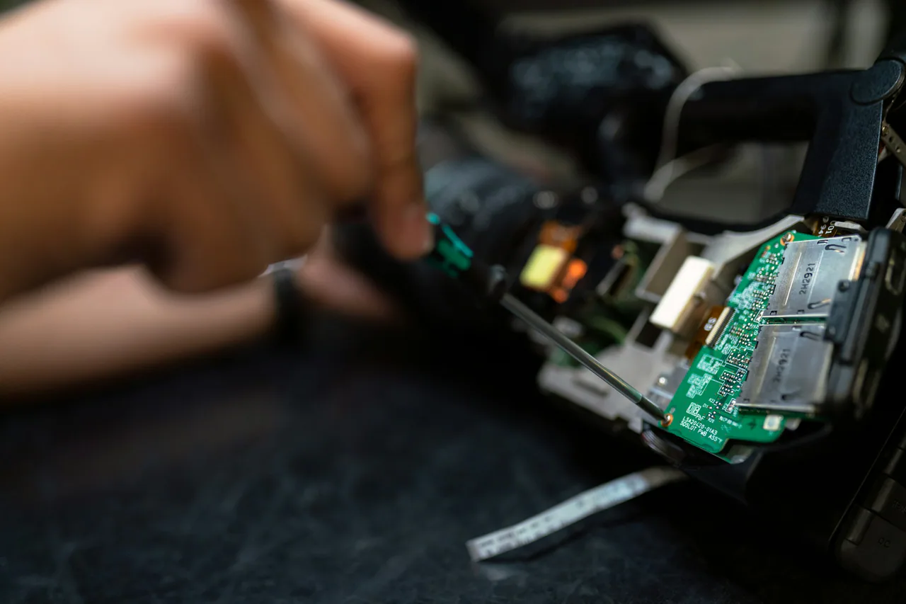 Açık elektronik devre kartını inceleyen teknisyen elleri